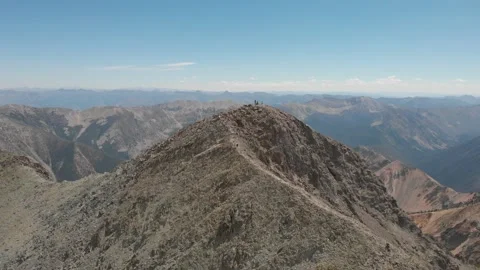 Fly away from people on top of massive peak Stock Footage 166372020
