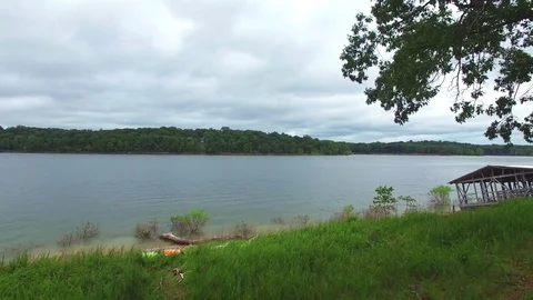 Fly Back away from lake next to trees Stock Footage 77698141