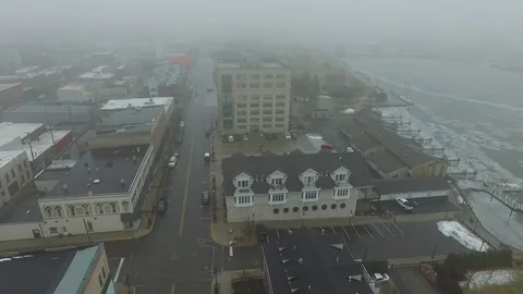 Fly back showing misty covered town Vidéo 72505001