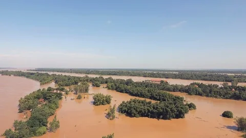 Fly backward over a tiny flooded hamlet on the edge of the Mekong river Video stock 87307570