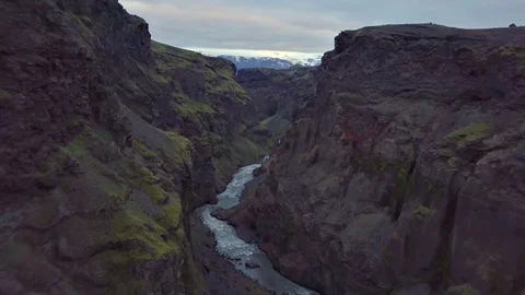 Fly backwards in dark river canyon in volcanic Iceland nature Stock Footage 105351493