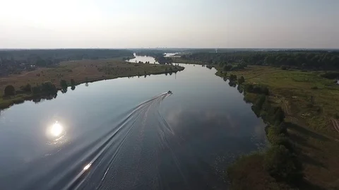 Fly behind a boat going down the river on a sunny day Stock Footage 71798657