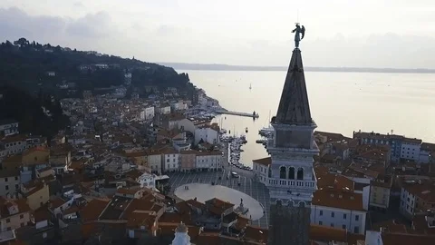 A fly by a church over the main square at a beautiful  mediterranean town Piran Stock Footage 82585482