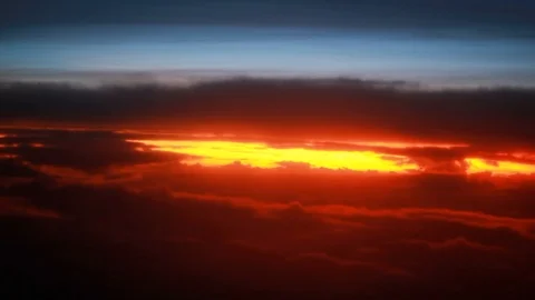 Fly by in the cloudy sky on the sunrise, window view from a plane Stock Footage 100226406