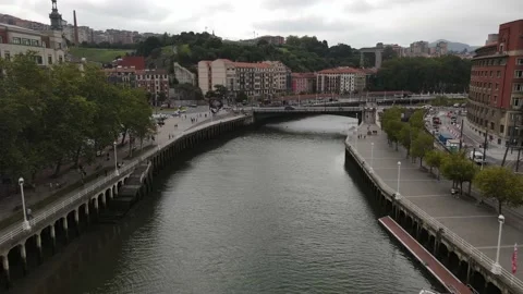 Fly down Nervión River downtown Bilbao - medium shot Stock Footage 223003888