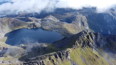 Fly down towards high lake in clouds part Stock Footage 219785750