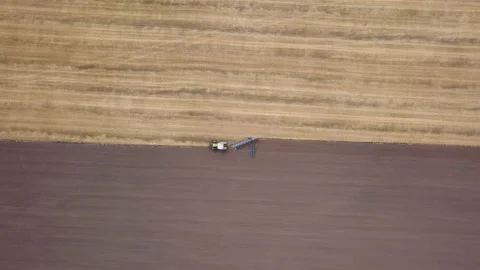  Fly down with turn over tractor with plough on field. Agricultural industry  Stockbeeldmateriaal 121701139