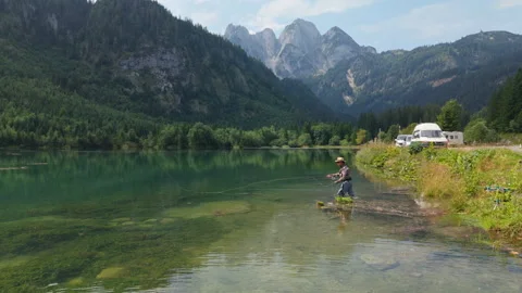 Fly fisherman casting in slow motion, scenic Austrian Alps - Aerial Stock Footage 331603464