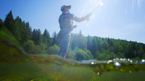 Fly fishing split underwater view. Angler stands in the river and casts the fly Video stock 155708083