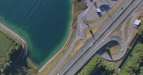 Fly high over road and lake - Aerial 4K 動画素材 67315087