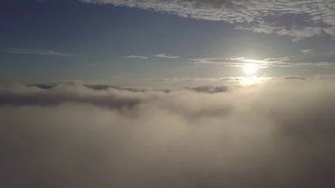 Fly moving backward, above the clouds during sunrise. Stock Footage 80017033