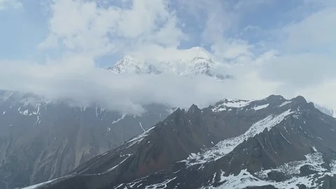 Fly near sharp snow rocks, sky-high Annapurna mountain towering in clouds,Nepal Stock Footage 124684797
