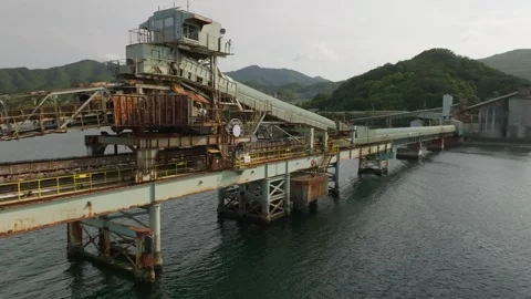Fly by old rusted conveyor on pier for loading ships with bulk materials Stock Footage 243013369