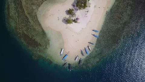 Fly over aerial small private paradise island top down with tourist boats Stock Footage 129058735