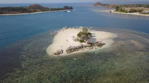 Fly over aerial small private paradise island top down with tourist boats Stock Footage 129060663
