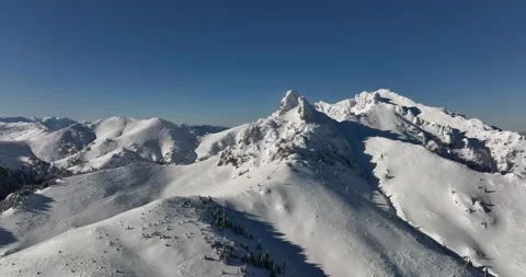 Fly over and around the mountains of Ciucas Romania in January 2022 Sunny day. Stock Footage 170199953