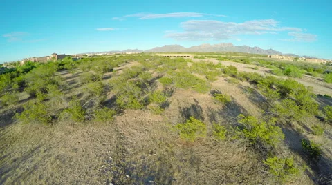 Fly Over Arroyo in Desert Toward Road Stock Footage 63435936