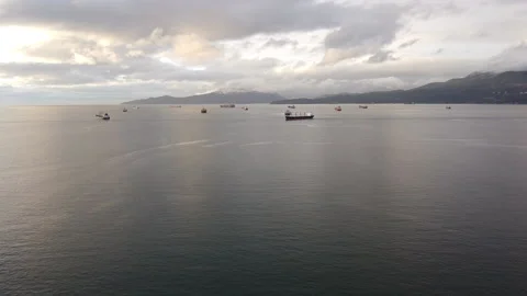 Fly over the bay in Vancouver with cargo ships waiting near the port Stock Footage 143421456