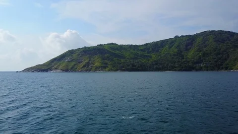 Fly over beautiful blue waters to green headland at west coast of Phuket Island Stock Footage 78360022