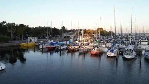 Fly over a boat filled harbor out to ocean at sunset Stock Footage 337072738