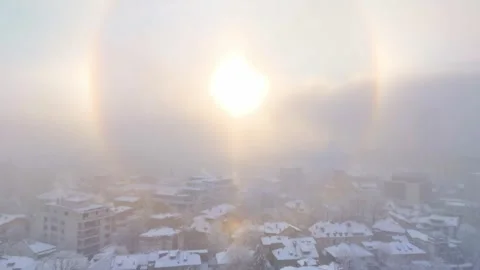 Fly over Bucharest City in winter season. Sun halo over the city Stock Footage 262573537