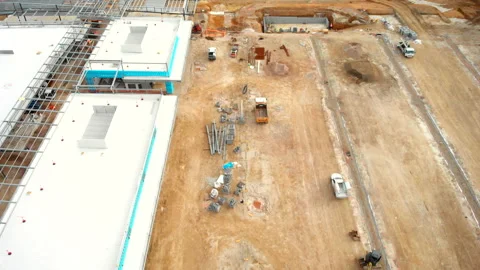 Fly over building construction site past dirt and machines Stock Footage 135204630