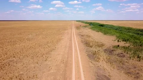 Fly over an empty dusty road via drone in desert or semi-desert region Stock Footage 141982416