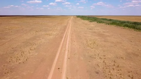 Fly over an empty dusty road via drone in desert or semi-desert region Stock Footage 141982460
