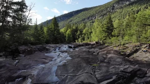Fly over flowing river with waterfall betwoon trees in Norway Stock Footage 248362386