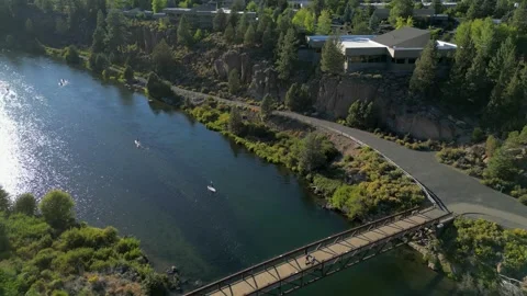 Fly Over Footbridge on Clear Summer Evening on River with Paddle Boards Video stock 249750192