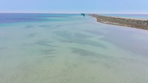 Fly over from a height of a kitesurfer trying to get to his feet and catch a Stock Footage 155804644