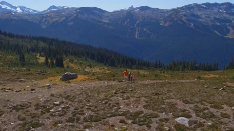 Fly Over Hikers on Dramatic Ridge with Mountains in Background Stock Footage 82636151