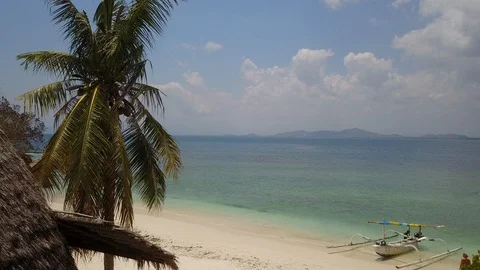 Fly over hut with palm tree on white sand beach with idyllic blue sea on island Stock Footage 129049508