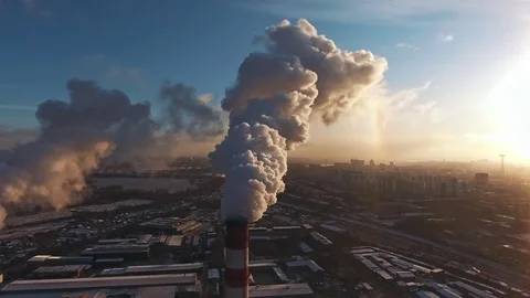 Fly over an industrial area with working pipes, smoke is pouring. Video stock 82257875