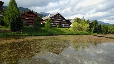 Fly over lake with beautiful chalets in a rural village in switzerland Stock Footage 128737265