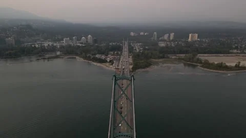 Fly over Lions Gate bridge with pan out over North shore sunset 動画素材 248480459