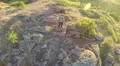 Fly up over man hiker tourist standing on hill top with sticks. Aerial HD Footage