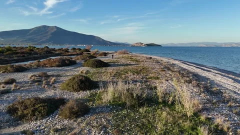 Fly over a man on the pebbly beach of Agios Andreas, Greece Stock-Footage 300266791