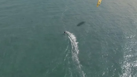 Fly over man practicing kite surfing and windsurfing on deep blue sea Stock Footage 229677515