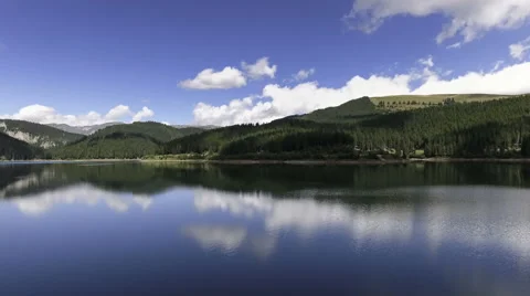 Fly Over Mirror Mountain Lake Surrounded By Forest Stock Footage 66418197