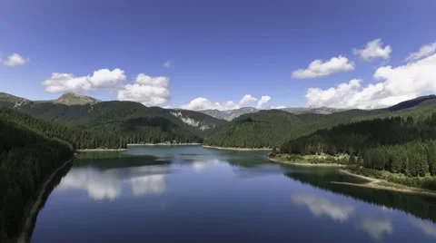 Fly Over Mirror Mountain Lake Surrounded By Forest Stock Footage 66418233