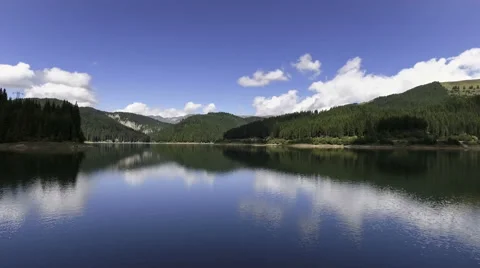 Fly Over Mirror Mountain Lake Surrounded By Forest Stock Footage 66418244