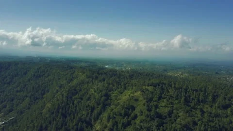 Fly over a mountain forest. Beautiful clouds against the blue sky in the horizon Stock Footage 131191758