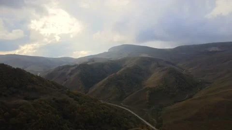 Fly over mountain peaks covered with bushes and forest in autumn. Stock Footage 145803523