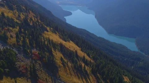 Fly Over Mountain side Forest Pan up to Alpine Lake in Background Stock Footage 82632545