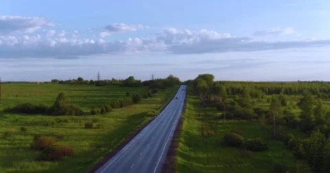 Fly over moving vehicles on the road in the countryside Stock Footage 77066316