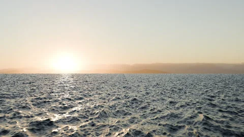 Fly over an ocean at sunset. cinematic of an ocean at sunset Stock Footage 337771596