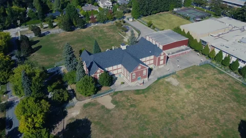 Fly over an old school in Canada. Empty soccer field and playgrounds Stock Footage 138811864