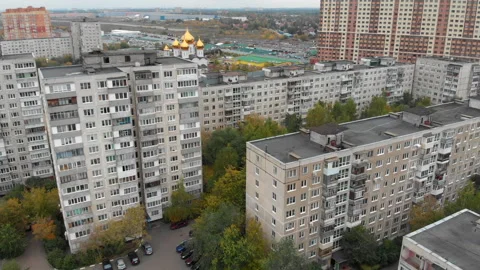 Fly over old Soviet-style multi-storey panel house with view on church Stock Footage 162170503