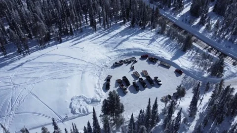 Fly over parking lot while snowmobilers arrive Stock Footage 310576393